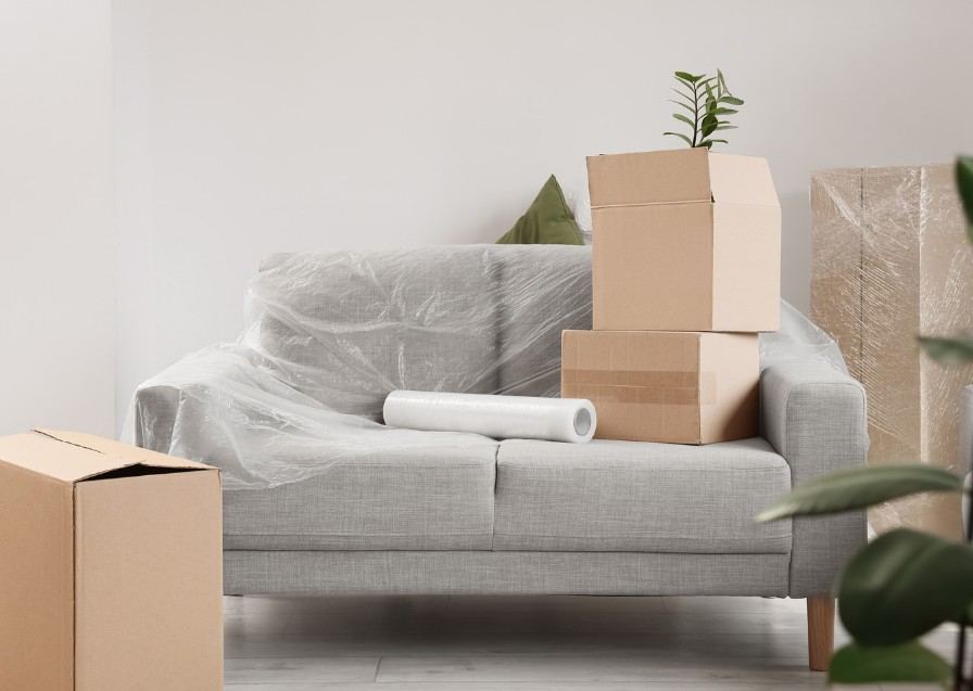 Recogida de muebles Sofá protegido con film y cajas de cartón preparadas para la recogida de muebles — Recogida de muebles